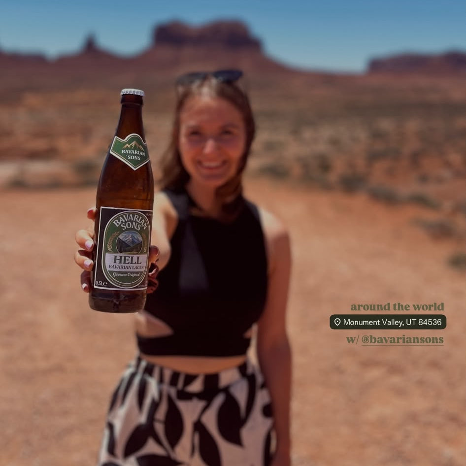 Helles Bier wird von einer hübschen Frau strahlend in die Kamera gehalten